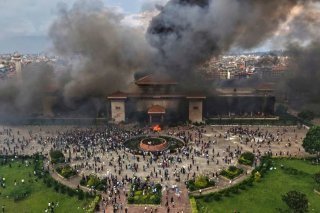 Des manifestants célèbrent devant le bâtiment du Parlement après qu'il a été incendié lors d'une manifestation contre l'interdiction des réseaux sociaux et la corruption à Katmandou, au Népal, le mardi 9 septembre 2025.